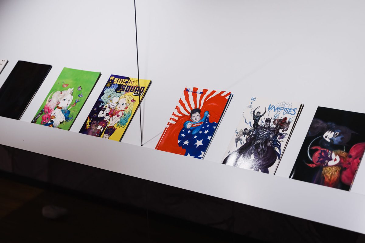 Icons section &mdash; DC Comics variant covers including Harley Quinn, Suicide Squad, Superman, and DC Vampires displayed on the exhibition shelf