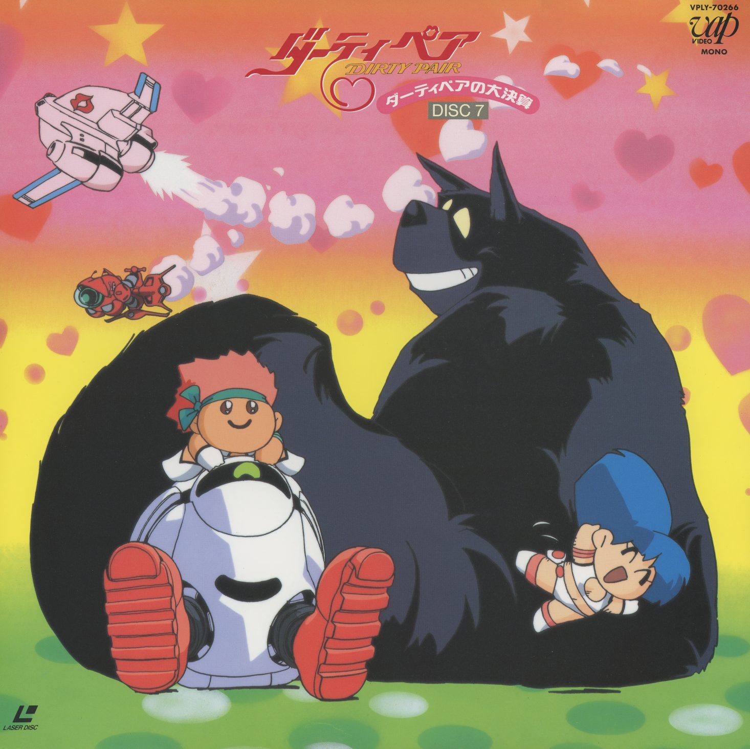 Disc 7 jacket — chibi Kei and Yuri seated with a giant Mughi on a green field, pink sky with hearts, small Lovely Angel in the upper left. TV specials 25–26 and OVA episodes 1–2. The transition cover: the franchise at its most consciously playful.