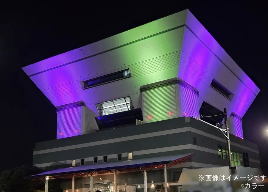 Minato Mirai building illuminated in Unit-01 purple and green &mdash; part of the satellite campaign's architectural lighting programme