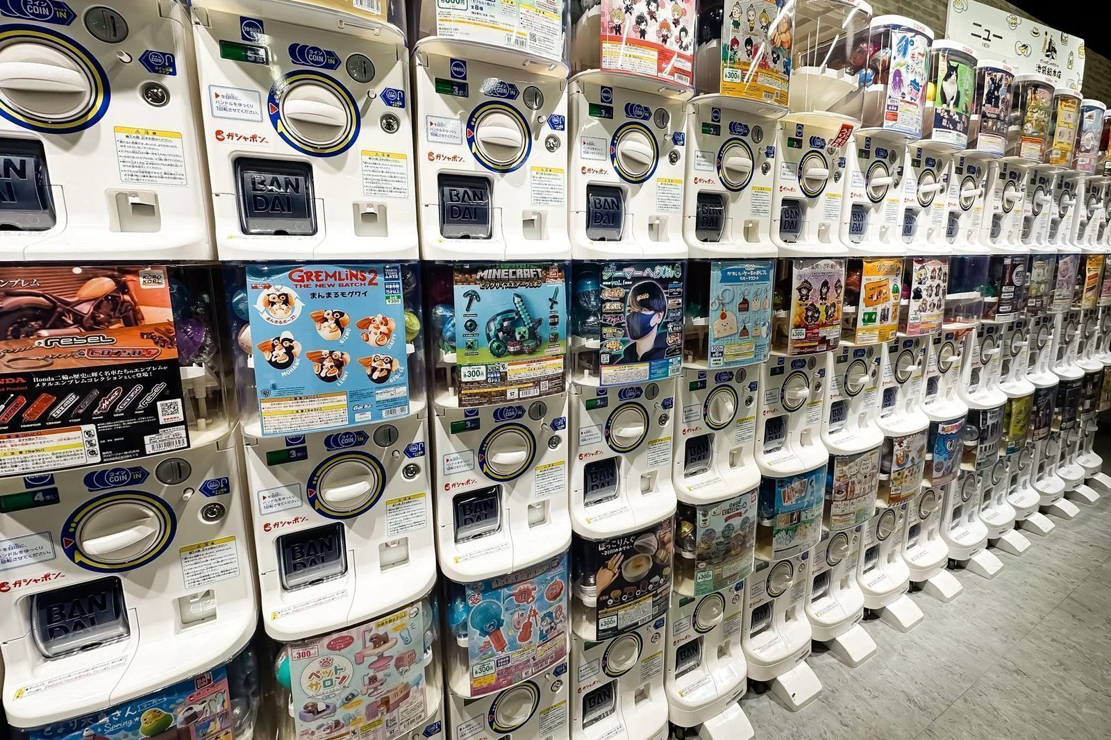 Machine rows organized by theme — each poster identifies the collection, price, and number of variants in the set