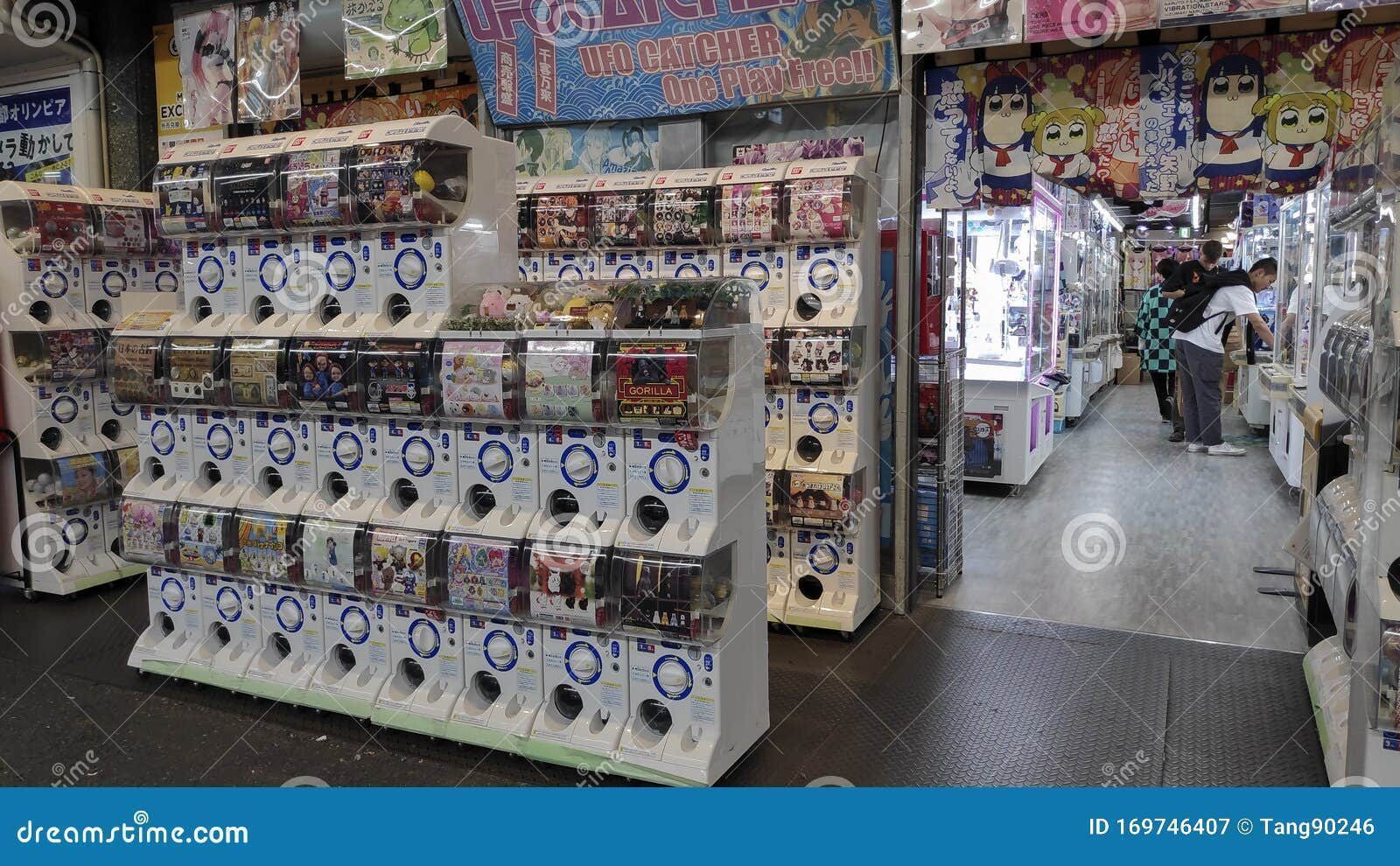 Gashapon machines outside a toy shop in Nishiki, Kyoto — the street-level encounter that plants the idea