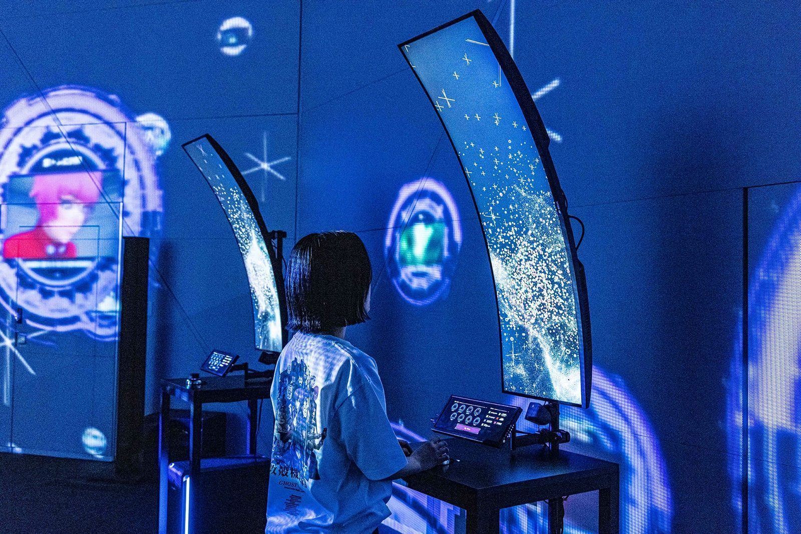 Visitor navigating the Nerve Net installation — curved screens display cascading network data, hands-on terminals allow exploration of Ghost in the Shell's information-space concepts