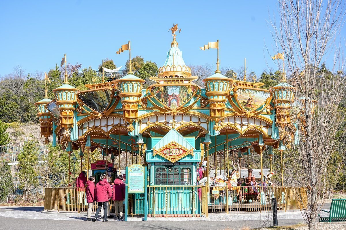 The Valley of Witches carousel &mdash; ornate teal and gold construction with Ghibli-themed vehicles