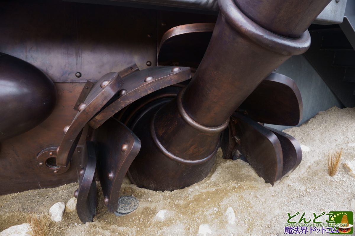 Copper leg joint &mdash; riveted metal bands and segmented structure at ground level, the patina developing differently at each exposure point