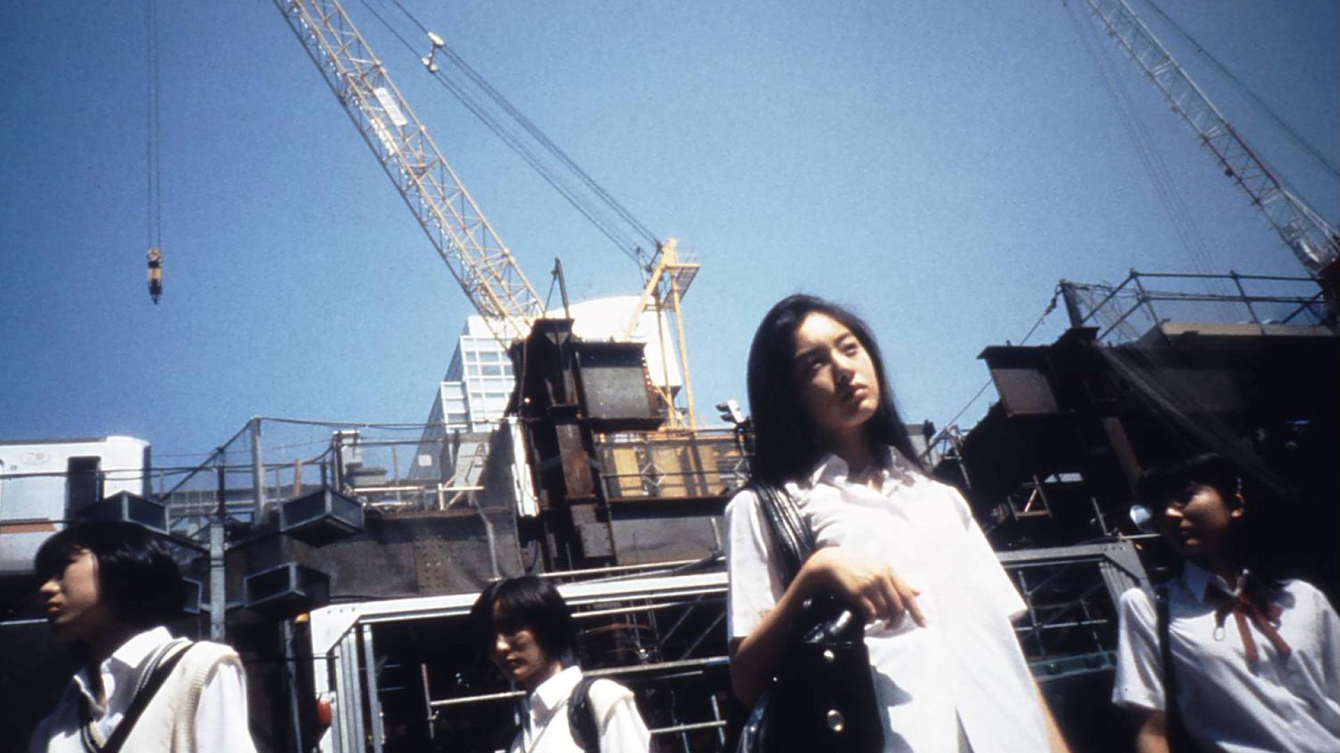 Film still — Hiromi (Miwa Asumi) in Shibuya. Shot on Sony DCR-VX1000 at 60fps. The consumer DV grain, the shallow color palette, the handheld instability — this is what Anno wanted the image to feel like.