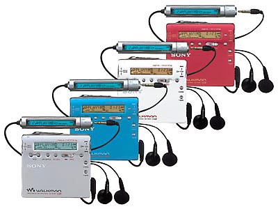 Sony MZ-R900 in four colours with earphones — portable recording designed to be carried. The format assumed you would take it on a train, into a pocket, through a commute