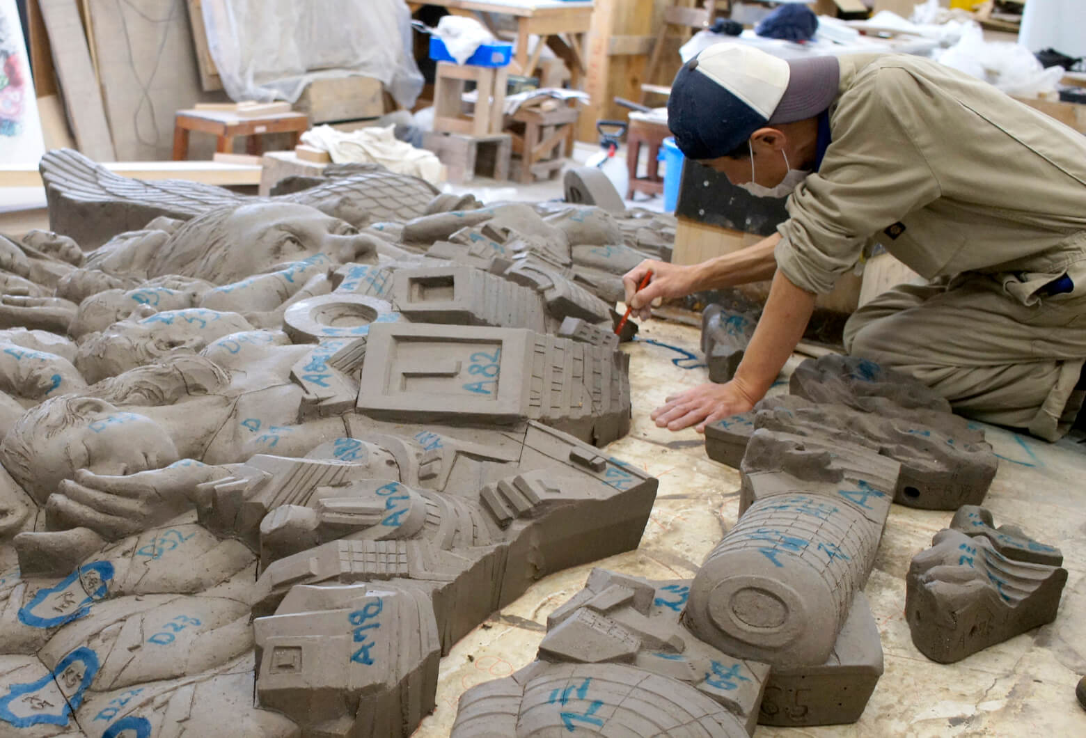 Cutting labeled sections from the clay master &mdash; grid positions A16, A82, D23 visible