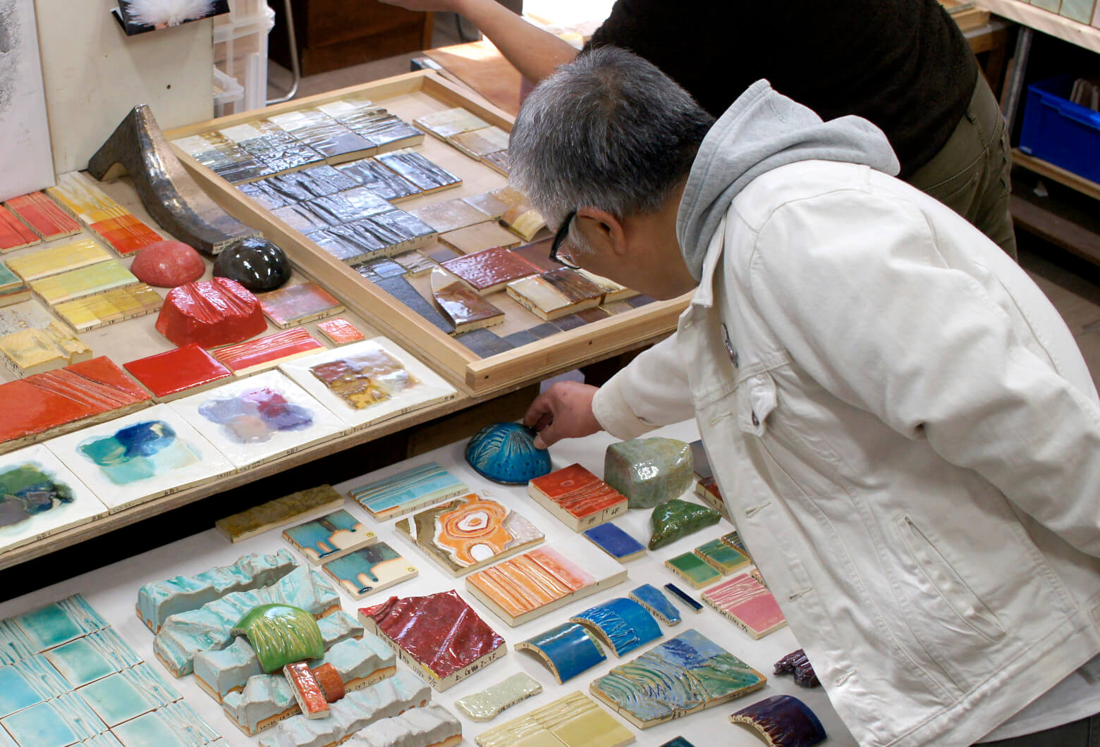 Otomo examining colored glaze test samples at CREARE