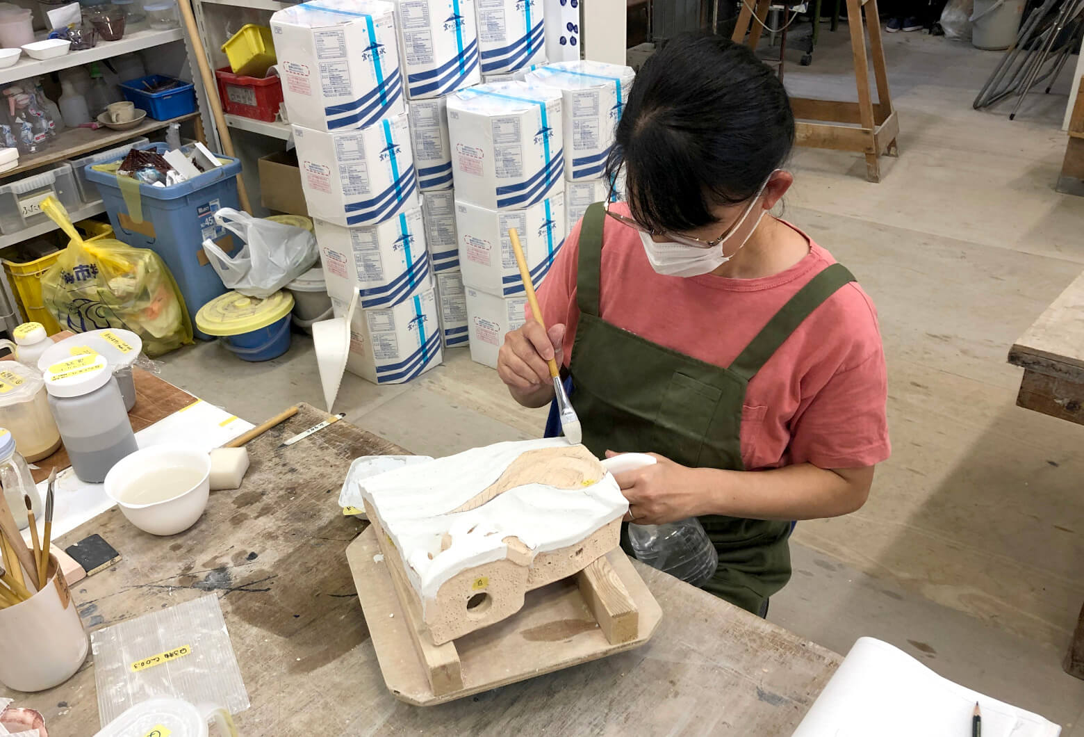 Artisan applying glaze to an individual ceramic piece &mdash; each of the 499 components glazed by hand
