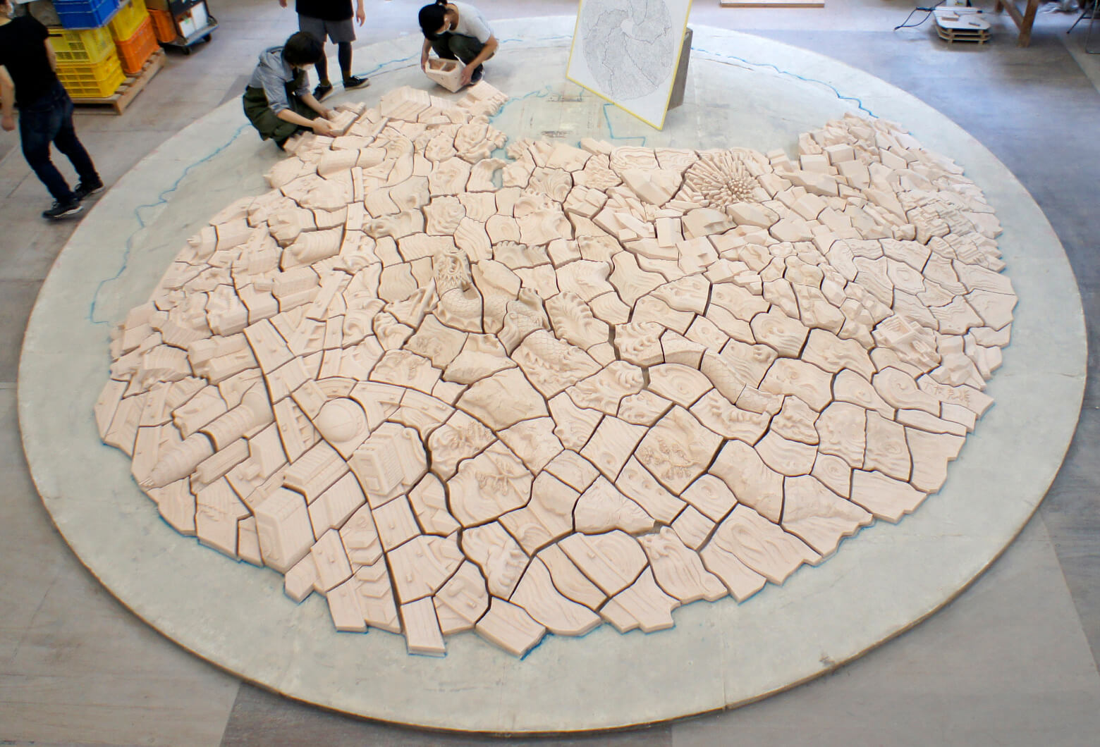 All ~499 unglazed pieces arranged in circular formation for verification before glazing